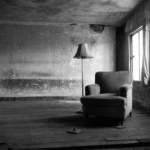 Tom lænestol i et slidt rum med dagslys fra et vindue